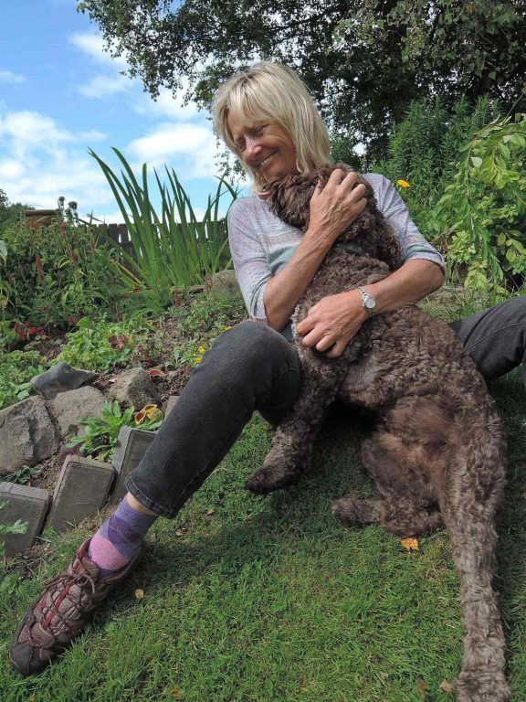 Barking Mad Dog Care Host Hugging Dog In Garden home boarding